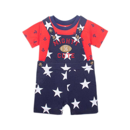 A baby short-sleeve romper set featuring navy blue overalls with white stars and 'MIGHTY CUTE 36' text, layered over a red t-shirt with small anchor prints.