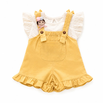A baby girl's two-piece outfit featuring mustard yellow corduroy overall shorts with a ruffled hem and shoulder straps, paired with a cream-colored ruffled short-sleeve top. The outfit is styled with a small doll charm on the chest and is photographed flat on a white background.